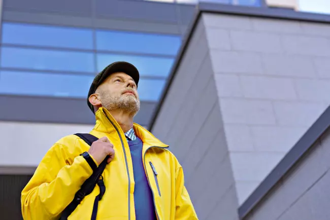 Kuva keltatakkisesta miehestä, joka katsoo ylös taivaalle